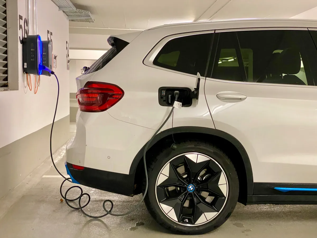 BMW iX3 Elektroauto beim Laden an einer Wallbox in der Tiefgarage